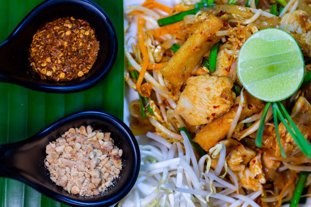 Pad Thai with rice noodles, bean sprouts, garlic chives and lime, served with crushed peanuts and chili flakes on the side